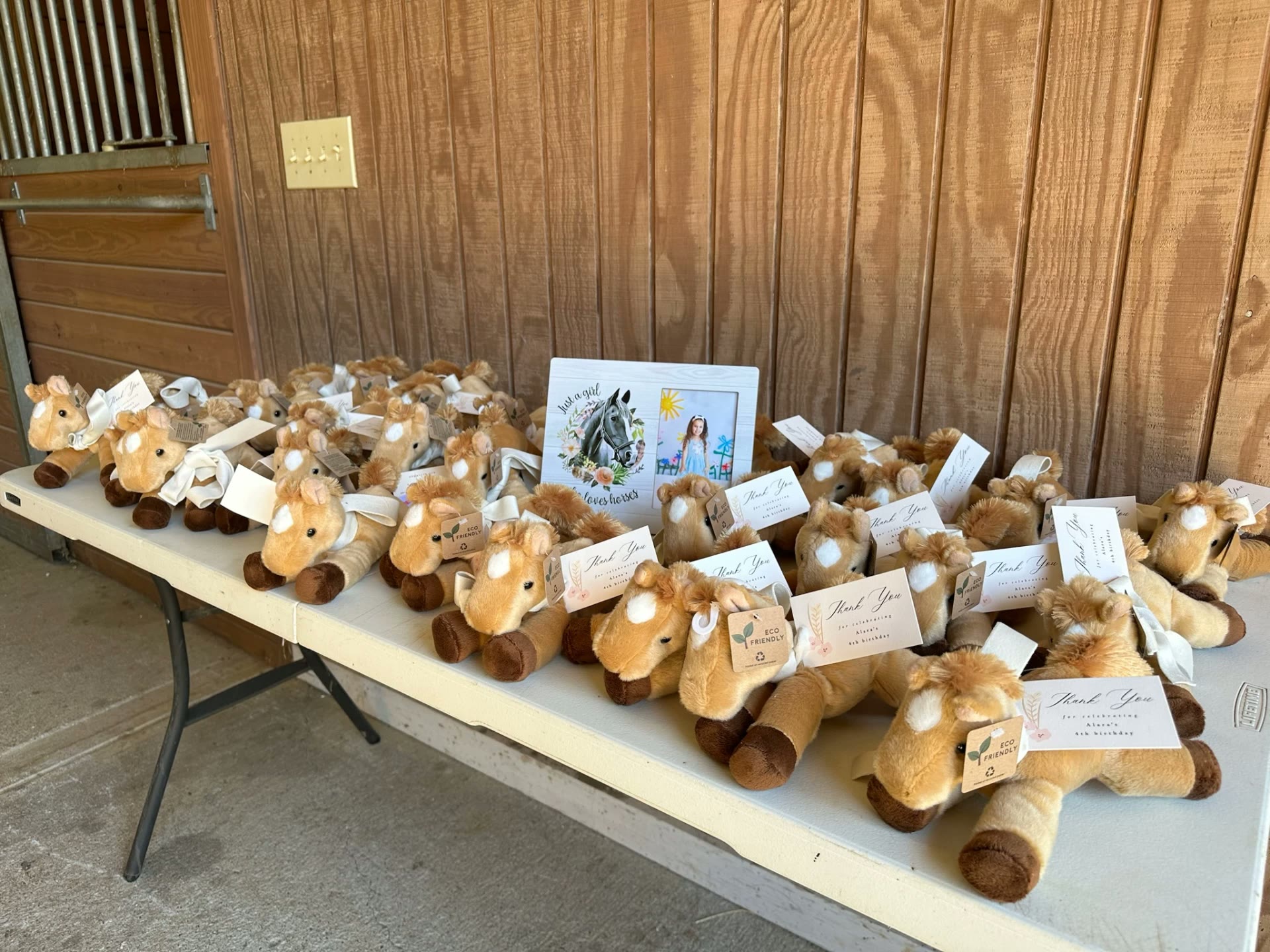 Plush horse party favors with thank-you tags at a farm-themed birthday