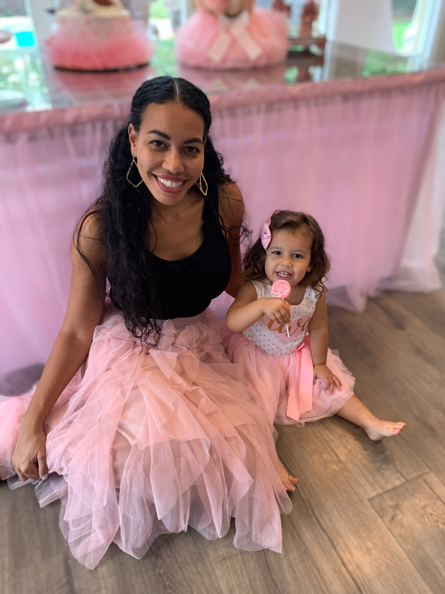 Melissa and her daughter in matching pink tulle skirts at a birthday celebration