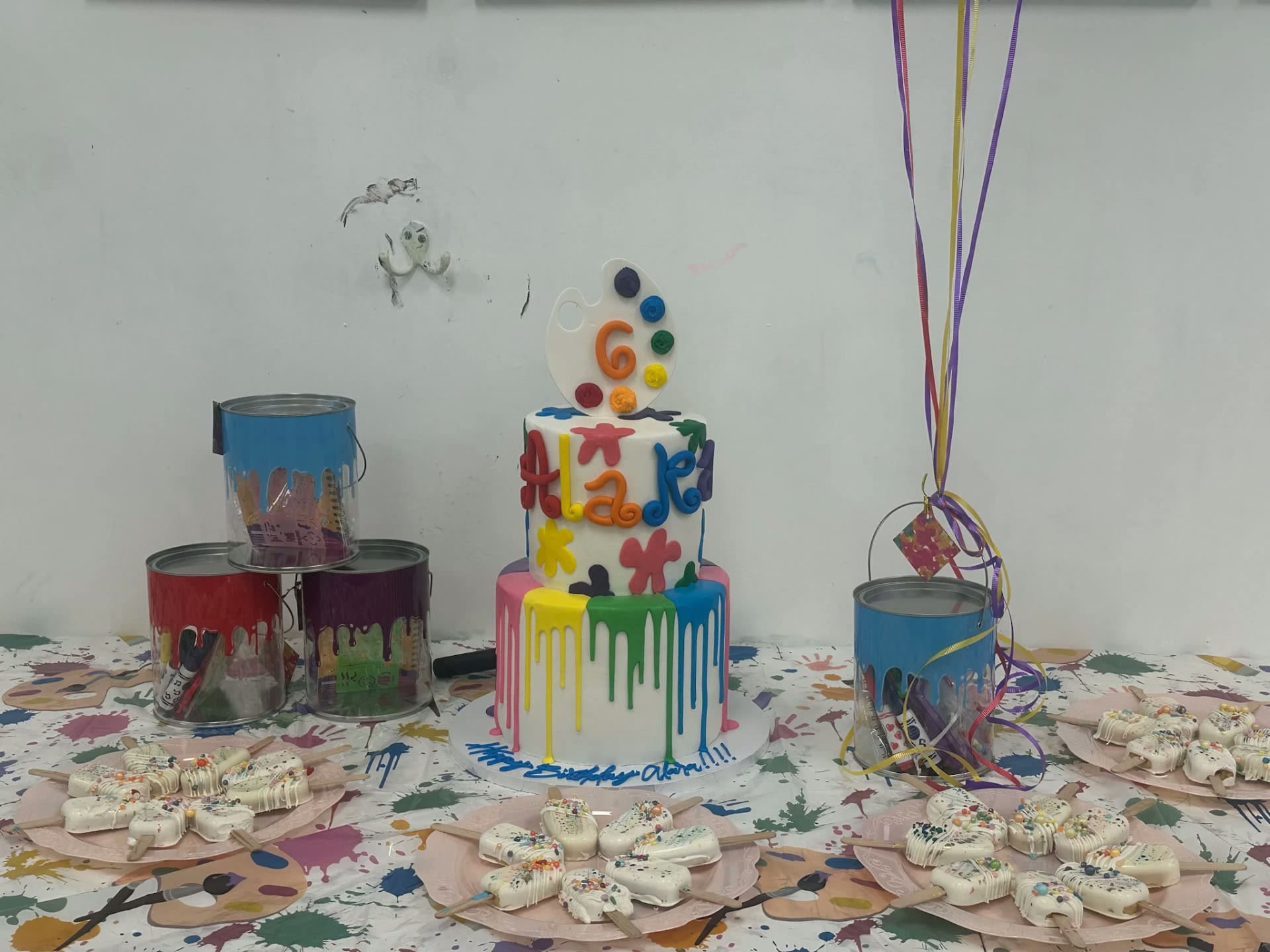 A paint-splatter birthday cake at an art party