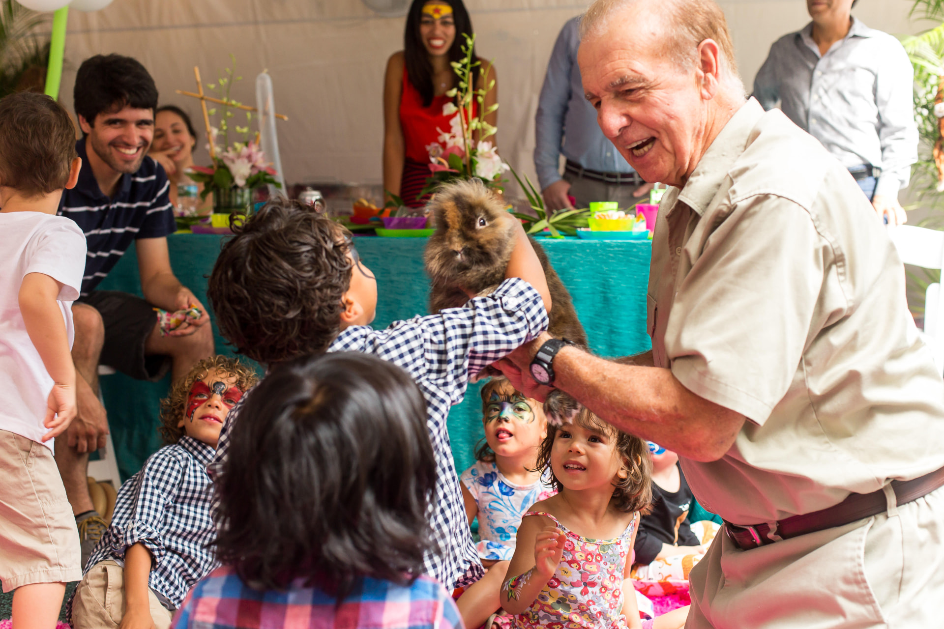 Children gathered around a fluffy guinea pig at a petting zoo birthday party
