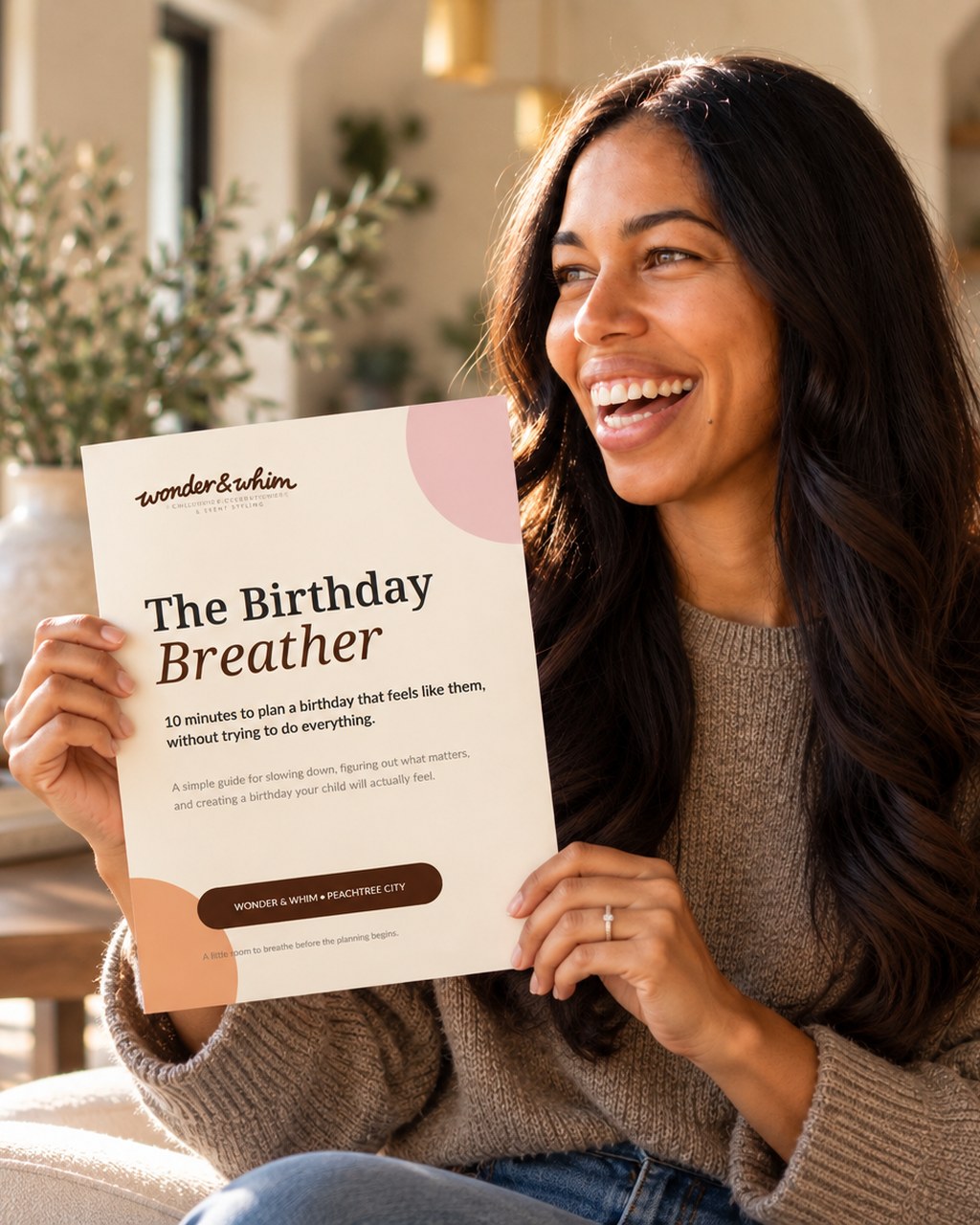 A smiling mom holding The Birthday Breather, a free 10-minute guide for parents